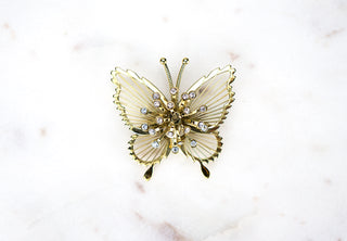 Filigree Butterfly Brooch Pin. Designer: Monet Period: 1960s Dimensions: 1.75”x2” Condition: Very good  An exceptional rendering of a butterfly by Monet with very delicate filigree framing centered with a dimensional burst of rhinestones. Available at Fonfrege.com